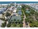 Aerial view showing tennis courts, lush landscaping, and ocean views at 5916 Midnight Pass Rd # 103, Sarasota, FL 34242