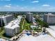 Aerial view of a beachfront community with multiple buildings, lush landscaping, and a pool at 5916 Midnight Pass Rd # 103, Sarasota, FL 34242