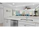 Kitchen features a double sink, stainless steel dishwasher and a view of the living room at 5916 Midnight Pass Rd # 103, Sarasota, FL 34242