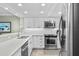 Modern kitchen boasts white cabinets, stainless steel appliances, and quartz countertops at 5916 Midnight Pass Rd # 103, Sarasota, FL 34242