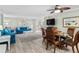 Open living and dining area with light flooring and blue sofas at 5916 Midnight Pass Rd # 103, Sarasota, FL 34242