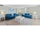 Living area featuring blue sofas, a coffee table, and a neutral color scheme at 5916 Midnight Pass Rd # 103, Sarasota, FL 34242