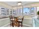 Sunroom with glass windows and ocean view, including a small table and chairs at 5916 Midnight Pass Rd # 103, Sarasota, FL 34242