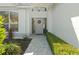 Inviting front entrance with a decorative wreath, stone pathway, and manicured hedges leading to the front door at 6416 Wentworth Xing, University Park, FL 34201