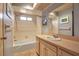 Traditional bathroom with a shower-tub combo features tile walls and a single sink vanity with a large mirror at 6805 13Th Avenue W Dr, Bradenton, FL 34209