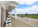 White columns and green cushions on rocking chairs on a patio overlooking the golf course at 7133 Cedar Hollow Cir # 22-102, Bradenton, FL 34203
