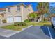 Tan two-story condo with two-car garage, lush landscaping, and palm trees at 7133 Cedar Hollow Cir # 22-102, Bradenton, FL 34203