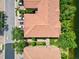 A high-angle view shows the red-tiled roofs of townhomes along a peaceful street and a tranquil lake at 7911 Moonstone Dr # 26-203, Sarasota, FL 34233