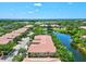 Aerial view of the homes lining a road alongside a scenic lake and lush landscape in the neighborhood at 7911 Moonstone Dr # 26-203, Sarasota, FL 34233