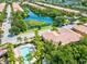 Aerial view of the community, featuring a scenic lake with fountain, pool, and well-maintained residences at 7911 Moonstone Dr # 26-203, Sarasota, FL 34233