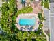Overhead shot of a beautiful community pool surrounded by tropical landscaping and lounge chairs at 7911 Moonstone Dr # 26-203, Sarasota, FL 34233