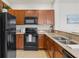 Well-equipped kitchen featuring granite countertops, stainless steel sink, and black appliances at 7911 Moonstone Dr # 26-203, Sarasota, FL 34233