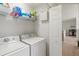 Convenient laundry area with a full-size washer and dryer, plus storage shelves at 7911 Moonstone Dr # 26-203, Sarasota, FL 34233