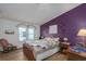 Bedroom with purple accent wall and quilt at 8520 Imperial Cir, Palmetto, FL 34221