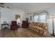Living room with floral sofa, two armchairs, and wood flooring at 8520 Imperial Cir, Palmetto, FL 34221