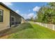Large backyard featuring well-maintained lawn, white picket fence, and the home's screened lanai at 9214 Raes Creek Pl, Palmetto, FL 34221