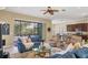 Open concept living room with large windows and seamless access to the kitchen at 9214 Raes Creek Pl, Palmetto, FL 34221
