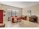 Cozy living room with tile flooring, a comfortable red sofa, and a stylish round glass coffee table at 9214 Raes Creek Pl, Palmetto, FL 34221