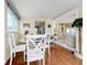 Dining area with a glass-top table and four white chairs, hardwood floors at 3333 26Th E Ave # 1120, Bradenton, FL 34208