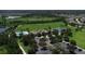 Aerial view featuring a community clubhouse, pool, tennis courts, and expansive green spaces for residents at 10817 56Th St E, Parrish, FL 34219