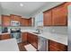 Cherry wood kitchen cabinets accented by quartz countertops and stainless steel appliances under natural light at 10817 56Th St E, Parrish, FL 34219