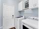 Bright laundry room with white cabinets, modern washer and dryer, and a fresh, organized space at 10817 56Th St E, Parrish, FL 34219