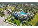 Aerial view of community pool, clubhouse, and surrounding landscape at 10931 Blue Magnolia Ln, Parrish, FL 34219