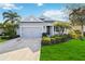 Attractive curb appeal featuring a two-car garage and manicured lawn at 10931 Blue Magnolia Ln, Parrish, FL 34219