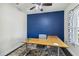 Home office with a blue accent wall and a modern desk at 10931 Blue Magnolia Ln, Parrish, FL 34219