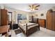 Comfortable bedroom showcasing a ceiling fan, light walls, tile flooring, and wood furnishings at 1119 76Th Nw St, Bradenton, FL 34209