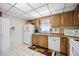 Kitchen featuring wood cabinets, white appliances, neutral countertops and tile flooring at 1119 76Th Nw St, Bradenton, FL 34209