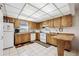 Cozy kitchen featuring wood cabinets, white appliances, tile floors, and a bright window for natural light at 1119 76Th Nw St, Bradenton, FL 34209