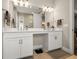 Double vanity bathroom with modern white cabinets and large mirror at 116 Daylily Blvd, Nokomis, FL 34275