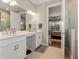 Double vanity bathroom with modern white cabinets and large mirror at 116 Daylily Blvd, Nokomis, FL 34275