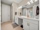 Double vanity bathroom with modern white cabinets and large mirror at 116 Daylily Blvd, Nokomis, FL 34275