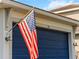 Garage with blue door and an American flag at 116 Daylily Blvd, Nokomis, FL 34275