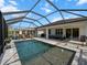 Enclosed pool area with patio furniture and lush landscaping at 116 Daylily Blvd, Nokomis, FL 34275