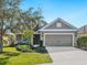 One-story home with gray siding, landscaping, and a two-car garage at 12310 Halfmoon Lake Ter, Bradenton, FL 34211