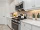 Modern kitchen with stainless steel appliances and white shaker cabinets at 12310 Halfmoon Lake Ter, Bradenton, FL 34211