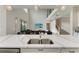 Kitchen island with white quartz countertop and double sink overlooking living area at 16446 Slate Pl, Bradenton, FL 34211