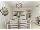 Bright dining room with a wooden table and white chairs, view of kitchen at 16706 Vardon Ter # 205, Bradenton, FL 34211