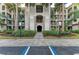 Condo building entrance with lush landscaping and parking at 16706 Vardon Ter # 205, Bradenton, FL 34211