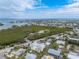 Aerial view showing a house near the water in a residential area with tropical vegetation at 220 82Nd St, Holmes Beach, FL 34217