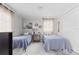 Bright guest bedroom with two twin beds and light wood floors at 2329 Outer Dr, Sarasota, FL 34231