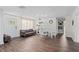 Spacious living room featuring hardwood floors, a brown leather couch, and a white grand piano at 2329 Outer Dr, Sarasota, FL 34231