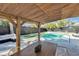 Relaxing pergola with dining table and chairs overlooking the pool at 2743 Fountain Pl, Sarasota, FL 34235