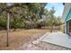 Large backyard with a stone path, mature trees, and a wooden fence at 3200 Tobero Ln, Sarasota, FL 34235