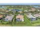 Aerial view of luxury homes with pools, lush landscaping, and scenic water views, showcasing a prestigious community at 3360 Founders Club Dr, Sarasota, FL 34240