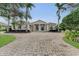 Elegant home exterior with columns, landscaping and a brick driveway at 3360 Founders Club Dr, Sarasota, FL 34240