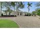 Elegant home with a circular driveway, manicured lawn, and vibrant flowers at 3360 Founders Club Dr, Sarasota, FL 34240